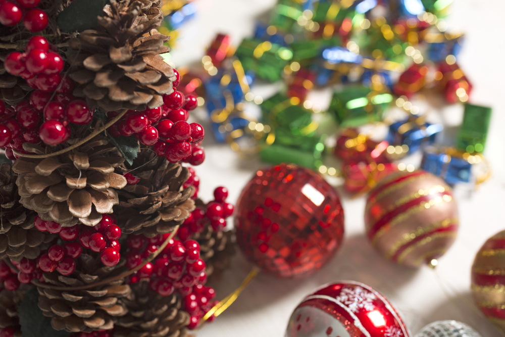 Selection of vibrant Christmas decorations on a light wooden surface